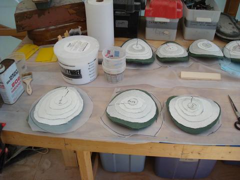 Laying the patches out . I use the foam and plastic as part of the system from holding them against the hull supported by "dead-man" stick.